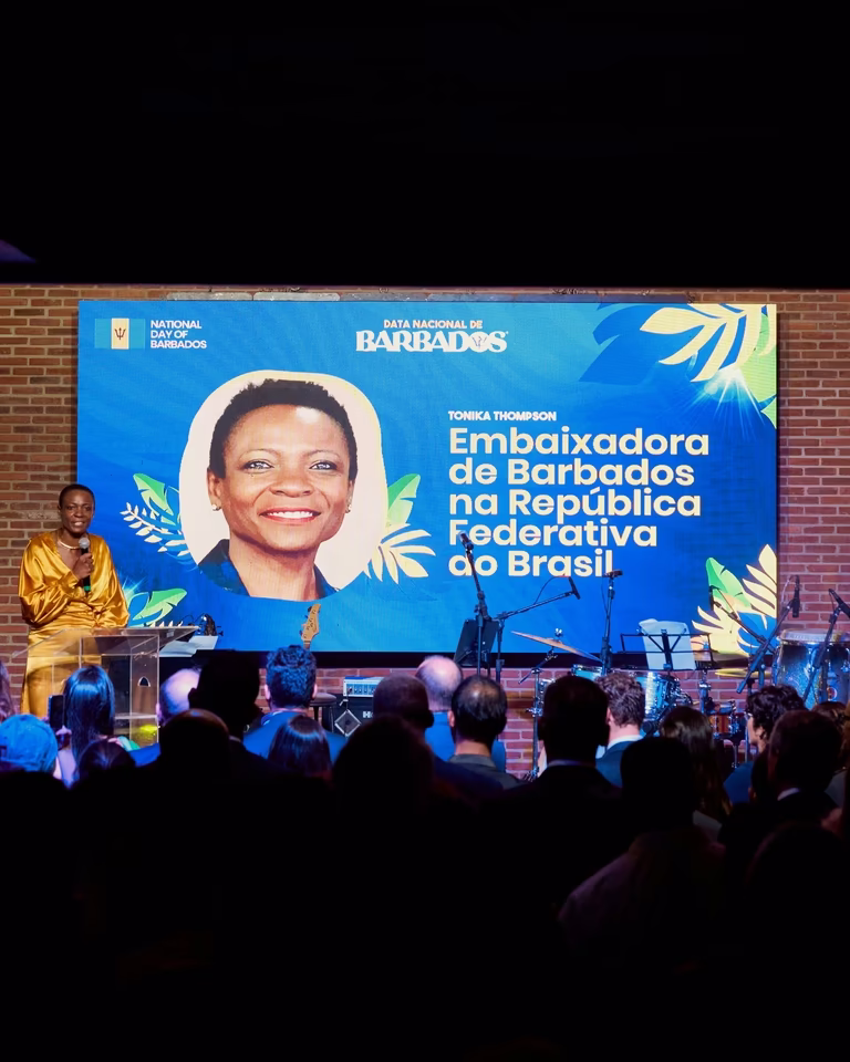 Telão azul apresenta a embaixadora Tonika Thompson ao público durante o evento