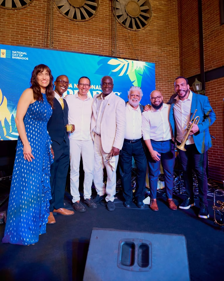 Músicos da banda posam com trompete diante do telão azul ao fim da celebração