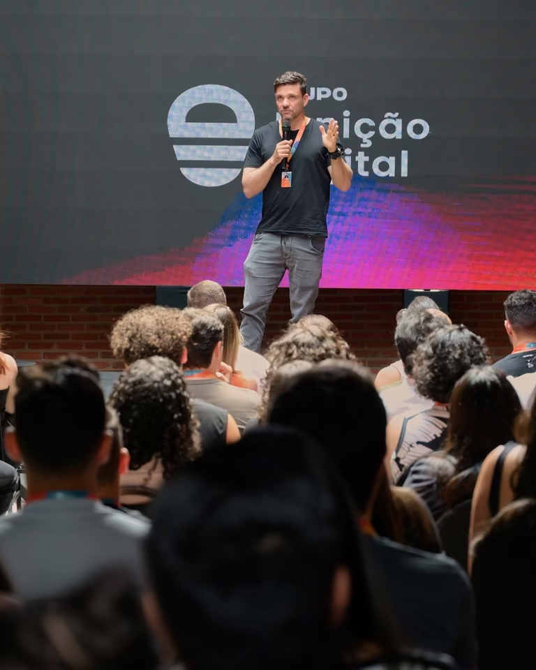 Palestrante no palco diante do telão do Grupo Ignição Digital