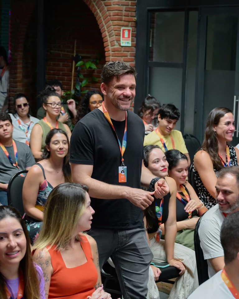 Apresentador sorridente interage com o público entre as cadeiras